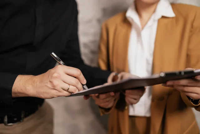 Dos personas firmando un contrato