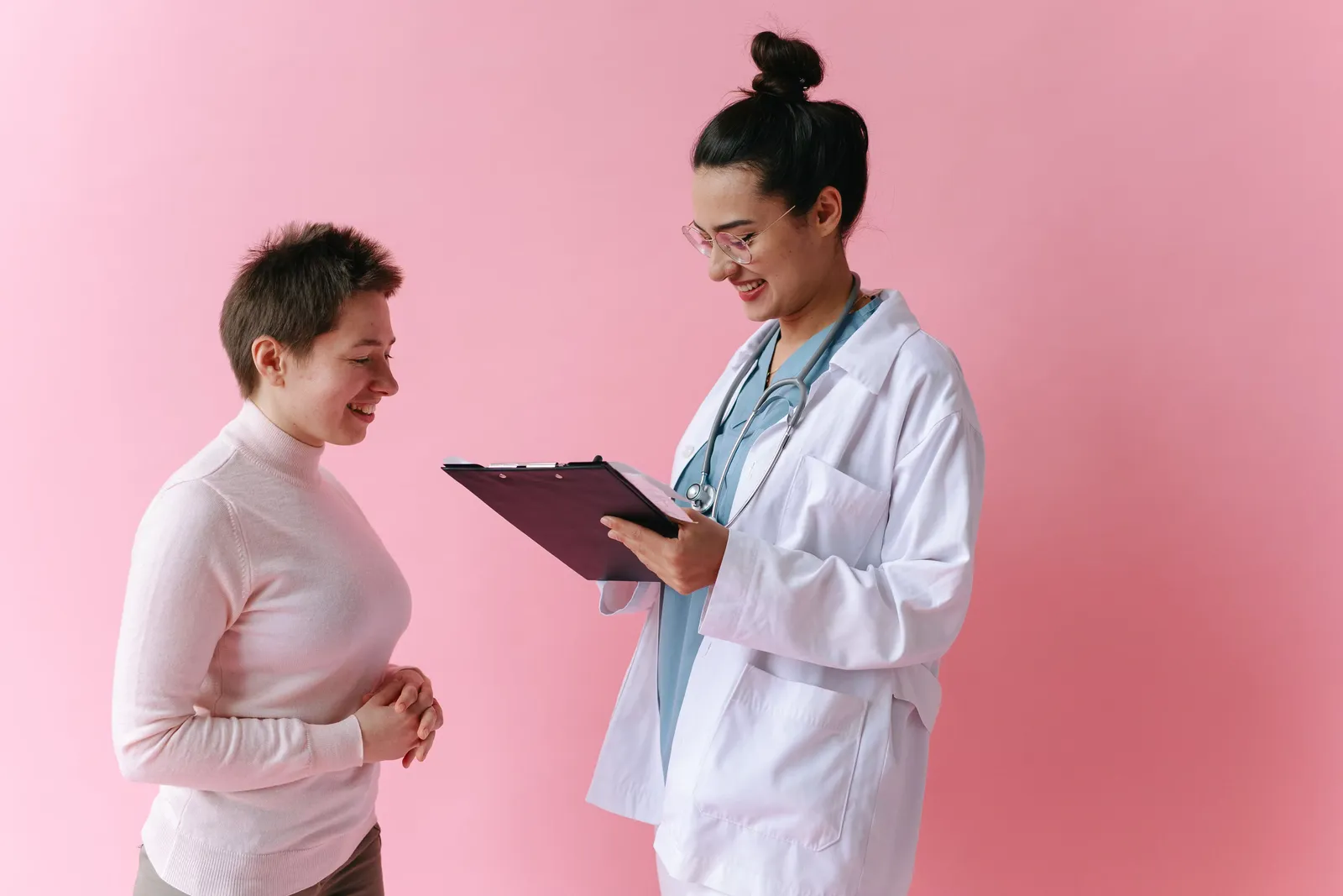 Médica con una carpeta conversando con una paciente
